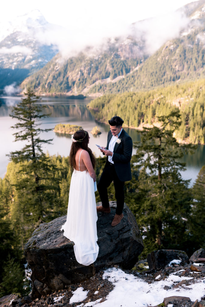 groom reads personal vows to bride at adventure elopement