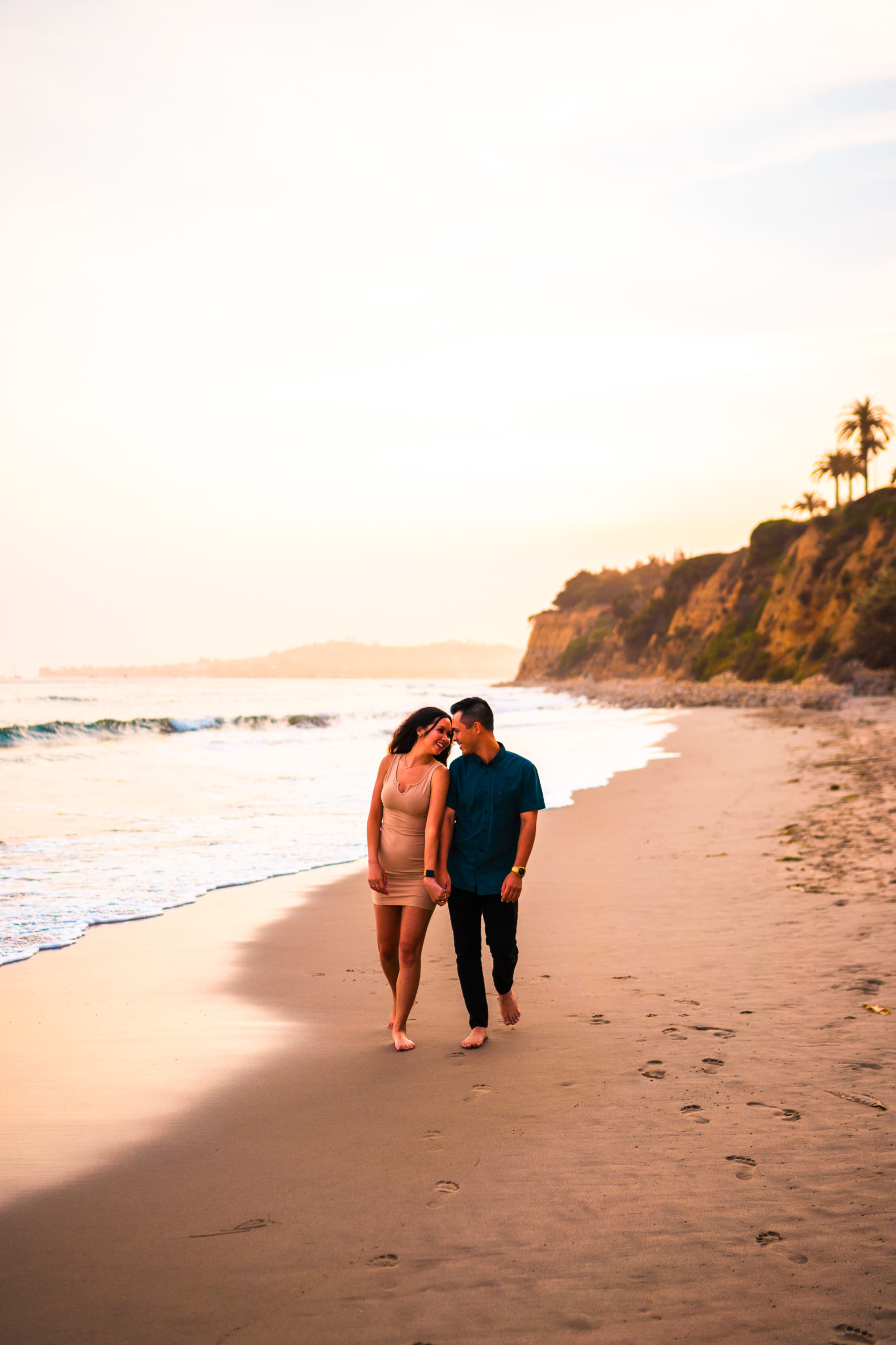 Couple walking down the beach during sunset
