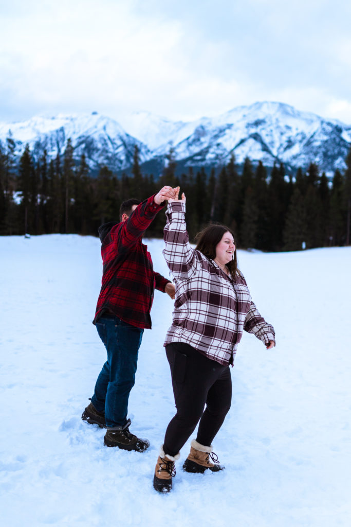 couple dancing in snow at engagement session in Canmore
