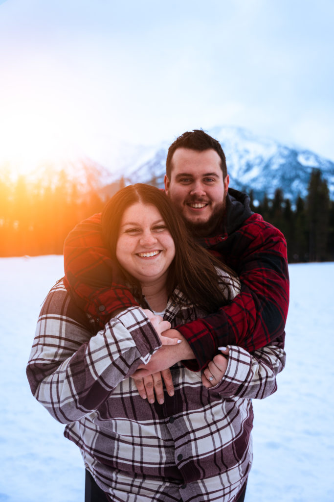 sun setting behind couple during Canmore engagement photo session