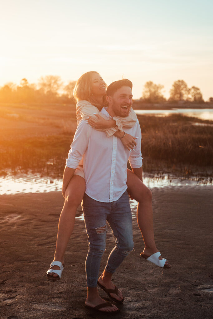 couple running around on beach during engagement photography session